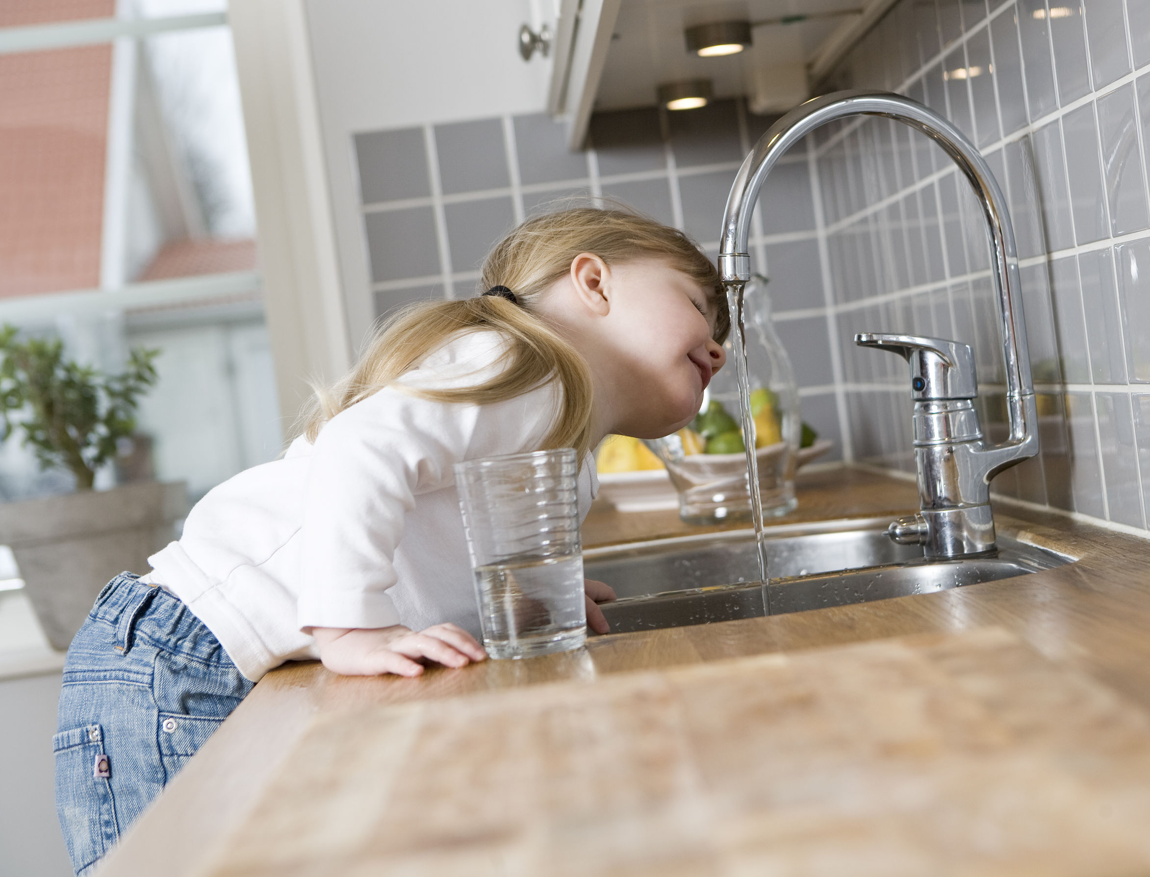 girl drinking from faucet