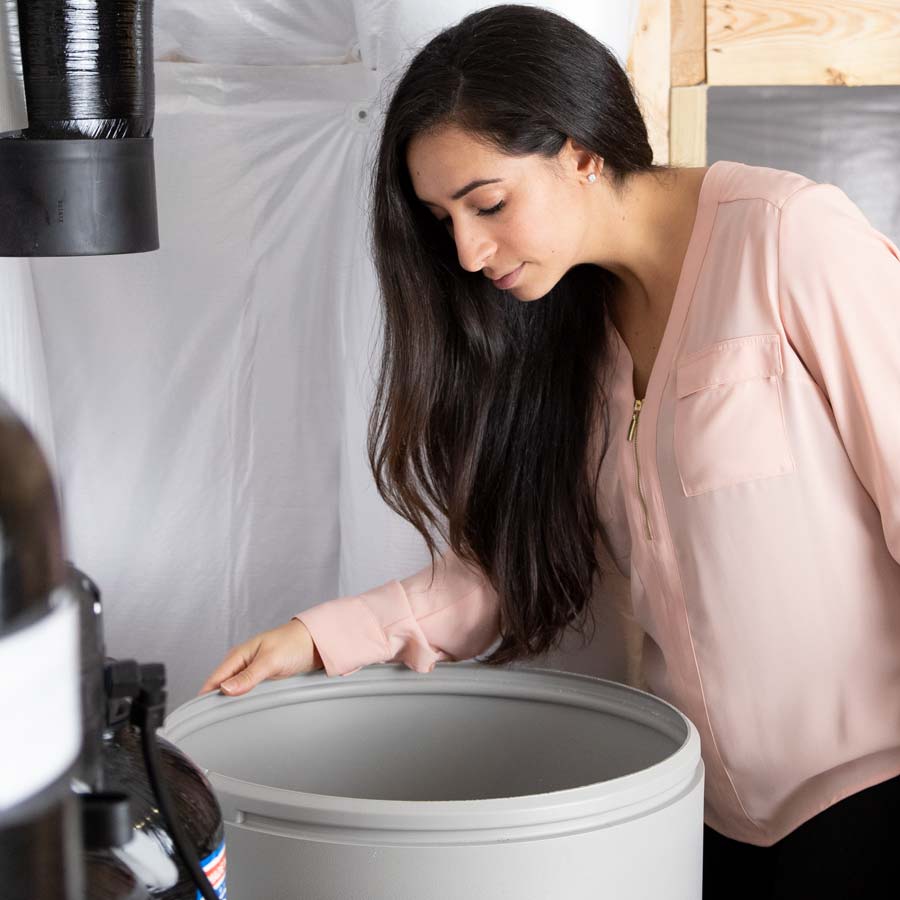 Woman looking inside of Water Softener Brine Tank