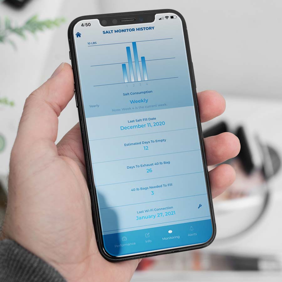 Man holding iPhone showing Kinex Salt Monitoring System